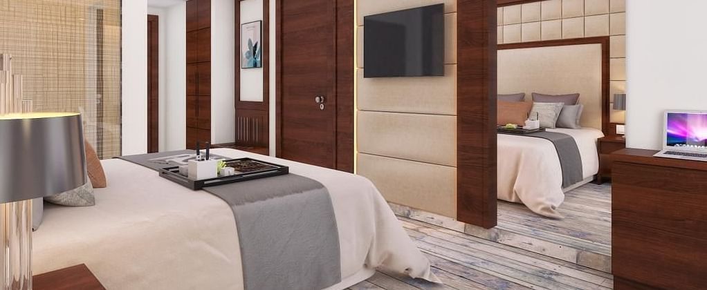A cozy room with a king-size bed, wall-mounted television, and warm lighting at BluSalzz Residence, Amritsar.
